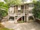 Exterior home view with tiered decks, stone accents, lush landscaping, and a gated driveway at 3115 Peachtree Ne Dr, Atlanta, GA 30305