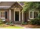 Inviting front entrance with a covered porch, decorative columns, and meticulous landscaping at 3115 Peachtree Ne Dr, Atlanta, GA 30305