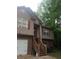 Two story home with tan siding, brick facade, red shutters, and wooden staircase at 143 Delane Dr, Dallas, GA 30157