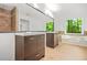 Bright primary bathroom with dual vanities, soaking tub, wood floors, and natural light at 230 Deer Forest Rd, Fayetteville, GA 30214