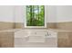 Close up of the built-in tub with tile surround and a large window view of the trees at 230 Deer Forest Rd, Fayetteville, GA 30214