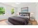 Comfortable bedroom featuring wood floors, a large bed, and picturesque views of the green outdoors at 230 Deer Forest Rd, Fayetteville, GA 30214