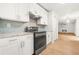 Modern kitchen featuring stainless steel appliances, white cabinetry, and light wood flooring at 230 Deer Forest Rd, Fayetteville, GA 30214