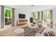 Cozy living room featuring bright windows, modern furniture, and new laminate flooring at 230 Deer Forest Rd, Fayetteville, GA 30214