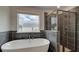 Modern bathroom with tiled shower, soaking tub, and window letting in natural light at 322 Delta Dr, Mcdonough, GA 30253