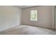 This is a carpeted bedroom with neutral walls and a bright window at 322 Delta Dr, Mcdonough, GA 30253