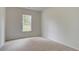 Empty bedroom featuring neutral carpet and natural light from a single window at 322 Delta Dr, Mcdonough, GA 30253
