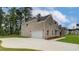 Side view of a brick home featuring an attached two-car garage and a well-maintained lawn at 322 Delta Dr, Mcdonough, GA 30253