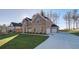 Brick home with an attached two-car garage and a spacious driveway, set against a backdrop of trees at 322 Delta Dr, Mcdonough, GA 30253