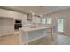 Bright kitchen boasts a center island with white countertops, stainless steel appliances, and ample cabinet space at 322 Delta Dr, Mcdonough, GA 30253