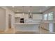 Modern kitchen featuring a center island, white cabinets, stainless steel appliances, and stylish pendant lighting at 322 Delta Dr, Mcdonough, GA 30253