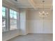 Bright and airy dining area showcasing tray ceilings, wainscoting, large windows, and a modern chandelier at 322 Delta Dr, Mcdonough, GA 30253