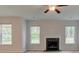 Bright living room features a fireplace and a ceiling fan, complemented by natural light streaming through three windows at 322 Delta Dr, Mcdonough, GA 30253
