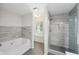 Well-lit bathroom with a separate soaking tub and glass-enclosed shower, designed for relaxation at 6071 Apple Grove Rd, Buford, GA 30519