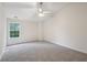 Spacious bedroom featuring a neutral carpet, ceiling fan and a bright window at 6071 Apple Grove Rd, Buford, GA 30519