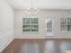 Bright dining area with a modern chandelier, wainscoting, and large windows at 6071 Apple Grove Rd, Buford, GA 30519