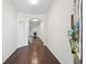 Hallway with hardwood floors, white walls, and an arched entryway leading to the living area at 6071 Apple Grove Rd, Buford, GA 30519