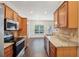 Open concept kitchen with stainless steel appliances, wood cabinets, and an adjacent dining area at 6071 Apple Grove Rd, Buford, GA 30519