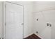 Bright laundry room featuring white walls, a door, a wire rack shelf, and hookups at 6071 Apple Grove Rd, Buford, GA 30519