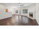 Spacious living room with fireplace, hardwood floors, large windows, and modern ceiling fan at 6071 Apple Grove Rd, Buford, GA 30519