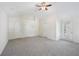 Vaulted main bedroom with neutral carpet, three doors, a window, and ceiling fan at 6071 Apple Grove Rd, Buford, GA 30519