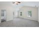 Vaulted main bedroom with neutral carpet, two windows, ceiling fan, and ensuite bathroom at 6071 Apple Grove Rd, Buford, GA 30519