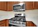 Close-up of a stainless steel gas range and microwave with light countertops and wood cabinets at 84 Mount Vernon Cir, Atlanta, GA 30338