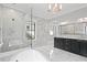 Bright bathroom with marble walls, a bathtub and a glass-enclosed shower at 908 N Highland Ne Ave, Atlanta, GA 30306