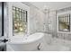Luxurious bathroom with soaking tub, marble accents, and sunlit windows at 908 N Highland Ne Ave, Atlanta, GA 30306