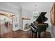 Living room showcasing grand piano, fireplace, and view into kitchen at 908 N Highland Ne Ave, Atlanta, GA 30306