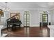 Elegant living room with dark hardwood floors, a black grand piano, and ample natural light through bright windows at 908 N Highland Ne Ave, Atlanta, GA 30306
