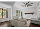 Bright living room showcasing neutral sofas, a decorative window, hardwood flooring, and a unique ceiling fan at 908 N Highland Ne Ave, Atlanta, GA 30306