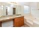 Bright bathroom with granite countertop vanity and a separate soaking tub at 137 Legend Creek Dr, Canton, GA 30114