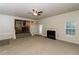 Cozy living room with fireplace, ceiling fan, and view into the kitchen at 137 Legend Creek Dr, Canton, GA 30114