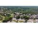 Scenic aerial view of a neighborhood bordering a lush green forest and a bustling commercial area at 214 Vickery Falls Dr, Roswell, GA 30075