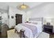 Primary bedroom with a tufted headboard, woven light fixture, hardwood floors and neutral colors at 214 Vickery Falls Dr, Roswell, GA 30075