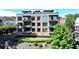Elegant brick building featuring large windows and private balconies, set against a backdrop of mature trees at 214 Vickery Falls Dr, Roswell, GA 30075