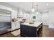 Modern kitchen with stainless steel refrigerator, white cabinets, island with seating and quartz countertops at 214 Vickery Falls Dr, Roswell, GA 30075