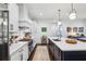 Bright kitchen featuring a long island with stainless steel appliances, quartz countertops and white cabinets at 214 Vickery Falls Dr, Roswell, GA 30075