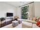 Cozy living area with large window, comfortable sofa, accent chairs, and modern entertainment center at 214 Vickery Falls Dr, Roswell, GA 30075