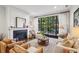 Cozy living room featuring a fireplace, large windows with natural light, and comfortable seating on hardwood floors at 214 Vickery Falls Dr, Roswell, GA 30075