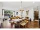 Elegant living room with hardwood floors, large windows, a modern table, and access to the dining area at 214 Vickery Falls Dr, Roswell, GA 30075