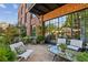 Outdoor patio with multiple seating areas surrounded by beautiful landscaping and brickwork at 214 Vickery Falls Dr, Roswell, GA 30075