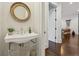 Powder room features a pedestal sink with decorative mirror and hardwood floors at 214 Vickery Falls Dr, Roswell, GA 30075
