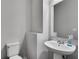 Simple half bathroom with a pedestal sink and modern fixtures, offering functionality and a clean aesthetic at 5437 Blossom Brook Dr, Sugar Hill, GA 30518