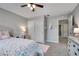 Bright bedroom with a ceiling fan, a bed with floral bedding, and a desk with a butterfly chair at 5437 Blossom Brook Dr, Sugar Hill, GA 30518