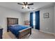 Cozy bedroom with a wooden bed frame, a ceiling fan, and natural light from the window at 5437 Blossom Brook Dr, Sugar Hill, GA 30518