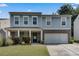 Two-story home with blue siding, brick accents, a two-car garage, and a well-manicured lawn at 5437 Blossom Brook Dr, Sugar Hill, GA 30518