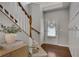 Bright foyer featuring hardwood floors, stairs with wood banister and board and batten trim at 5437 Blossom Brook Dr, Sugar Hill, GA 30518
