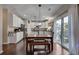 A modern kitchen features an island, granite countertops, white cabinets, stainless appliances, and a wooden dining table at 5437 Blossom Brook Dr, Sugar Hill, GA 30518